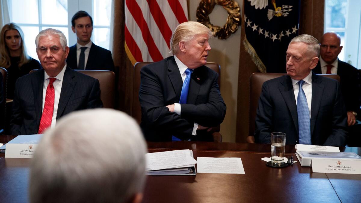 Secretary of State Rex Tillerson, left, and Secretary of Defense Jim Mattis, right, listen as President Donald Trump speaks during a cabinet meeting at the White House on Dec. 20.
