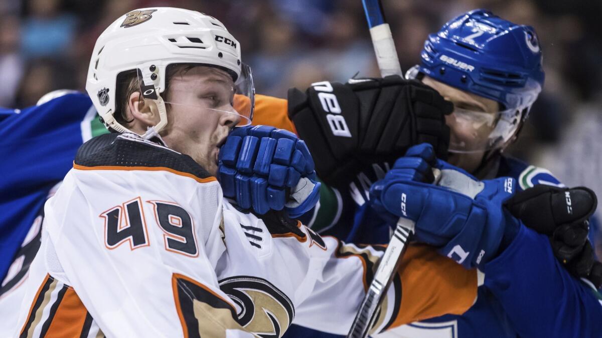 Ducks forward Max Jones, left, and Vancouver Canucks defenseman Luke Schenn get into a scuffle during a game on Feb. 25.