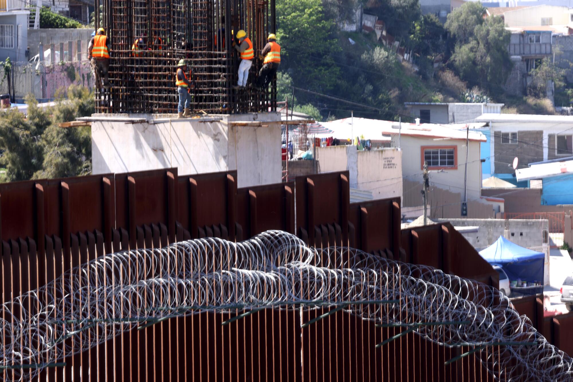 Construction workers in Tijuana work along the U.S.-Mexico border.