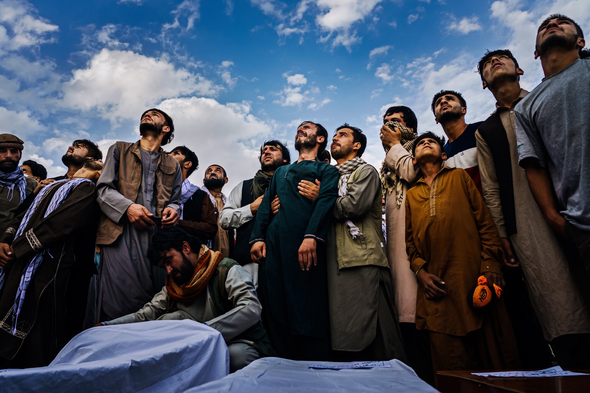 Afghani mourners look to the sky.