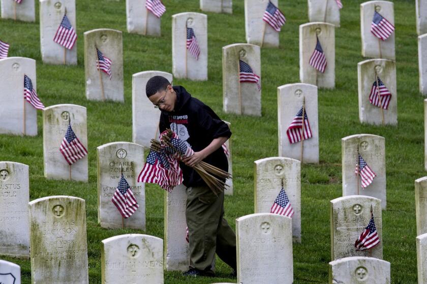 Boy Scout Daniel Perez, 11, of New York, places American Flags on graves at Cypress Hills National Cemetery in the Brooklyn borough of New York, Saturday, May 25, 2013. Members of the Girl Scouts, Boy Scouts and other volunteers placed the memorial flags on grave-sites for veterans of the Civil War, American Revolution, Spanish-American War, Korean and Vietnam wars in honor of Memorial Day. (AP Photo/Craig Ruttle) ** Usable by LA and DC Only **