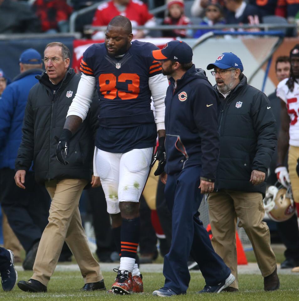 Martellus Bennett is assisted off the field after injuring himself on a play against the 49ers in the third quarter at Soldier Field.