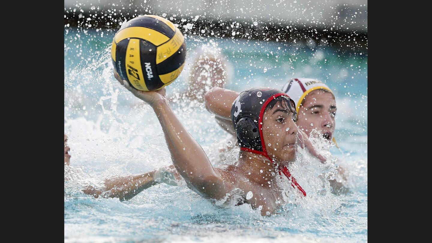 Burroughs' Marko Vucetic fights free of the Arcadia defense to shoot and score in the Pacific League boys' water polo semifinals at Arcadia High School on Tuesday, October 24, 2017.