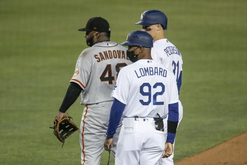 Dodgers first base coach George Lombard looks on during the fourth inning.