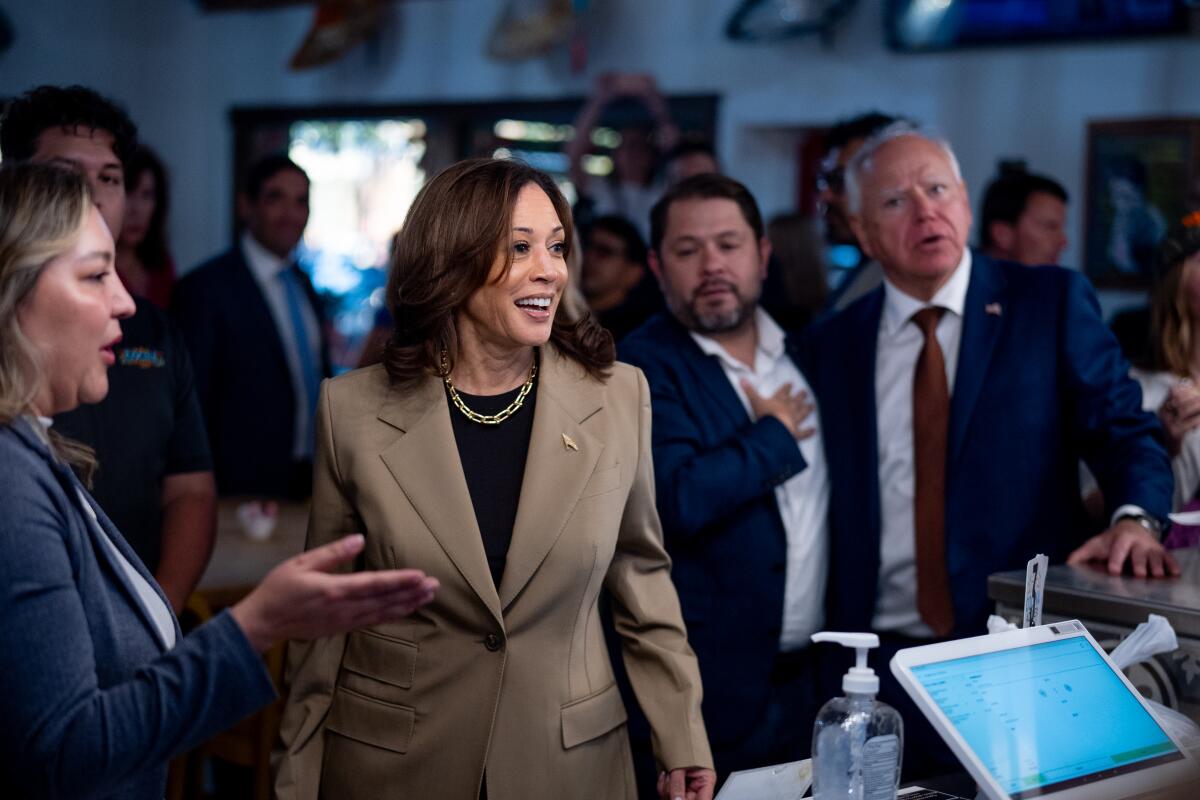 Vice President Kamala Harris stands in a restaurant with other politicians.