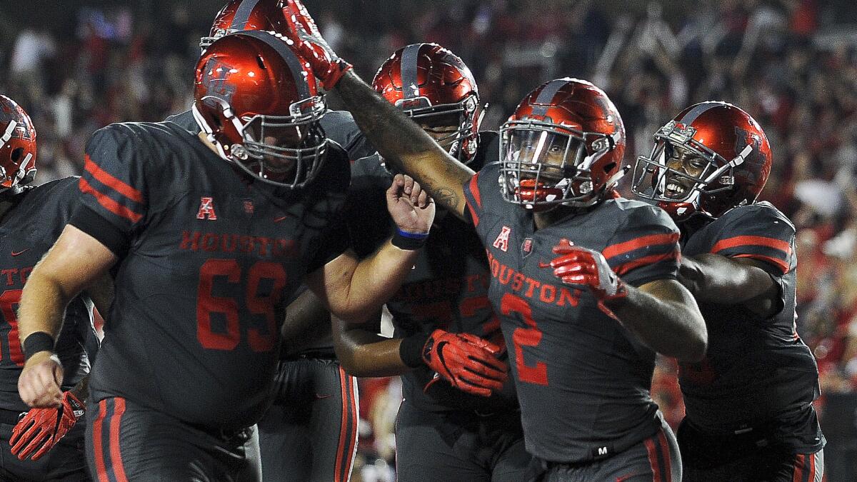 Houston running back Duke Catalon (2) celebrates his 13-yard touchdown reception against Louisville with teammates during the first half Thursday.