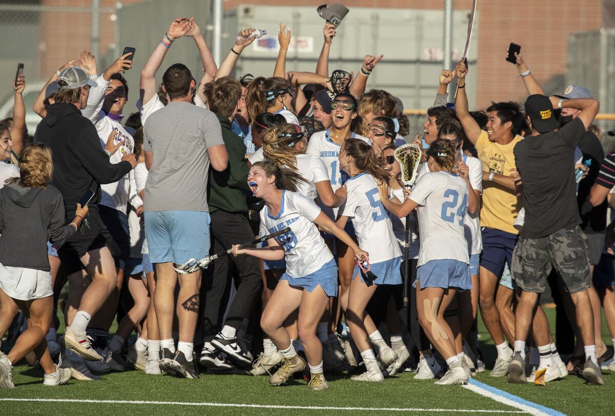 Fans and Corona del Mar girls' lacrosse players celebrate after beating Canyon on Wednesday.