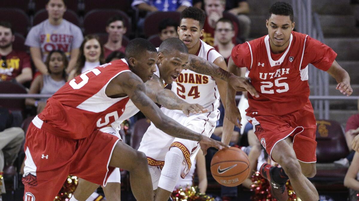 Utah's Delon Wright, left, and USC's Darion Clark, center, chase after a loose ball during the Trojans' 67-39 loss Sunday at the Galen Center.
