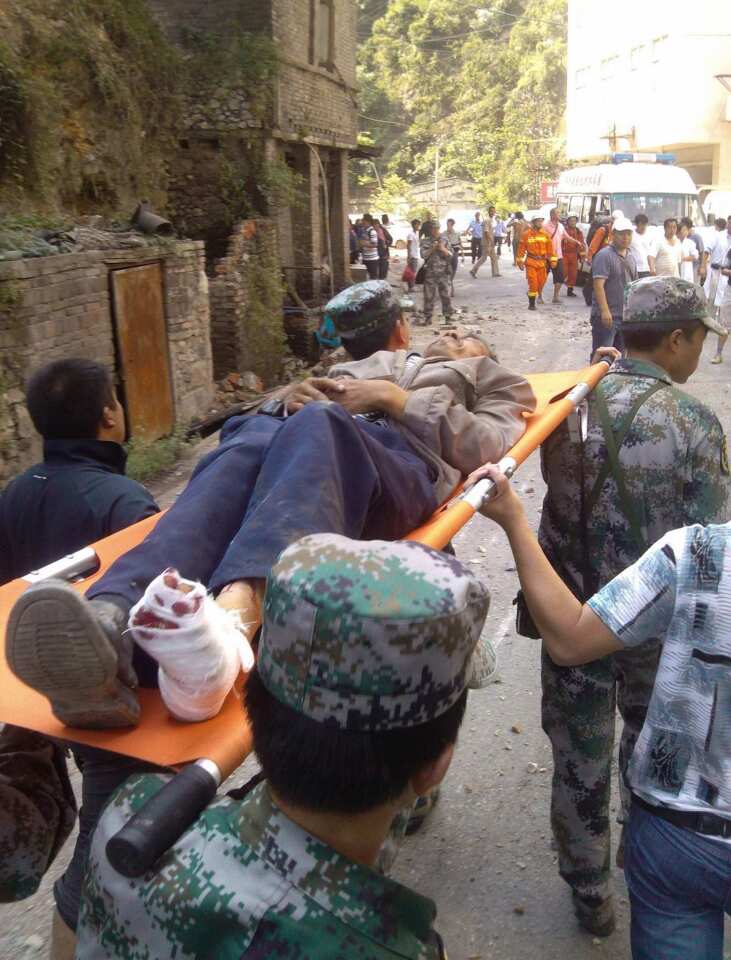 An injured villager is carried on a stretcher by rescuers following an earthquake in Luozehe town, Yiliang County, southwest China's Yunnan Province.