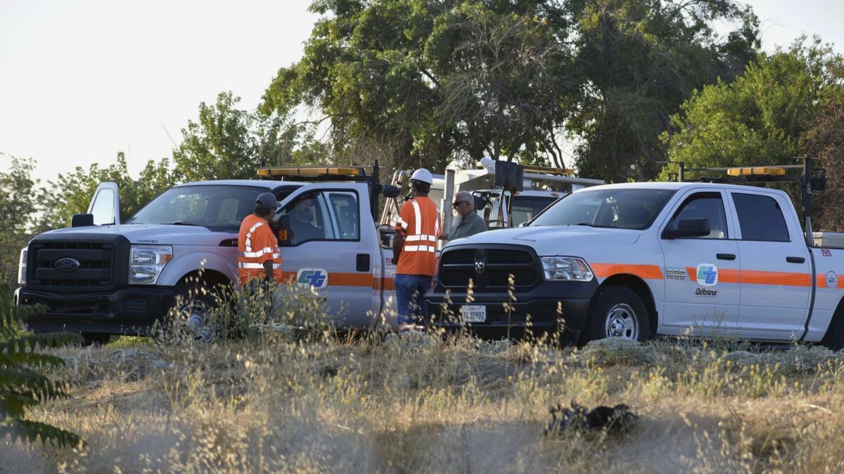 Caltrans workers gather near a field in Modesto near where Shannon Marie Bigley frequently slept. Her family has filed a wrongful death claim with the state agency.