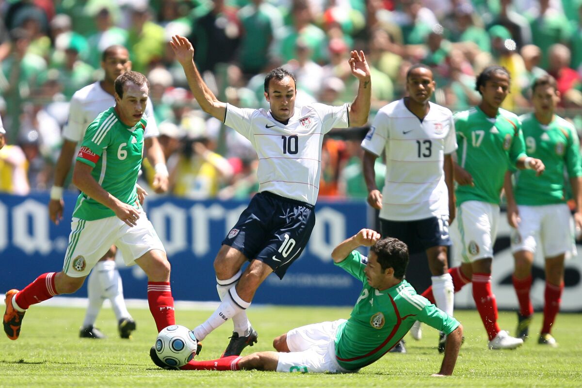 Mexico's Jose Antonio Castro slides and pokes the ball away from American Landon Donovan during a World Cup qualifier.