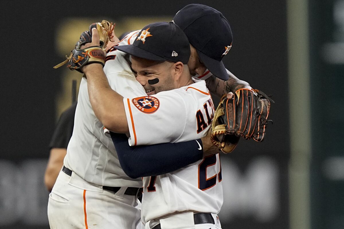 Houston Astros shortstop Carlos Correa celebrates their win with Jose Altuve against the Boston Red Sox in Game 1 of baseball's American League Championship Series Friday, Oct. 15, 2021, in Houston. (AP Photo/David J. Phillip)