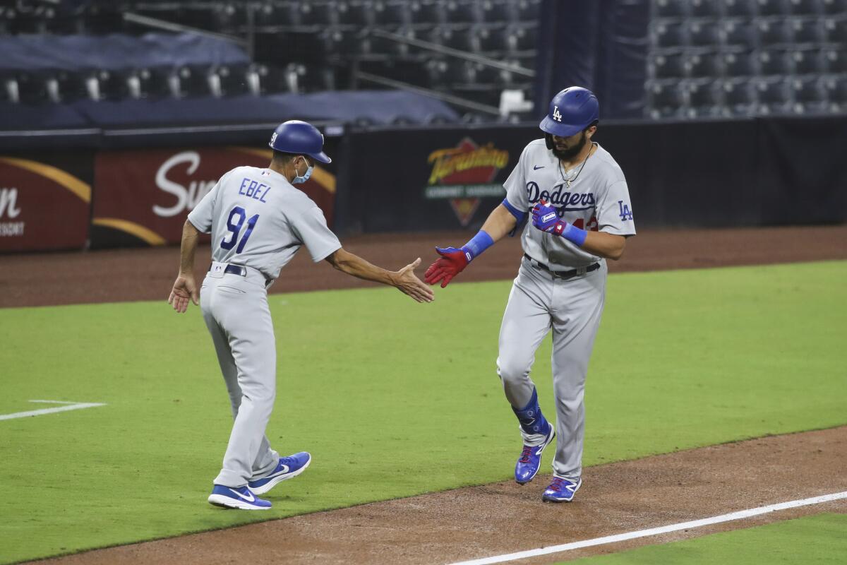 Dodgers third base coach Dino Ebel greets Edwin Rios as rounds third.