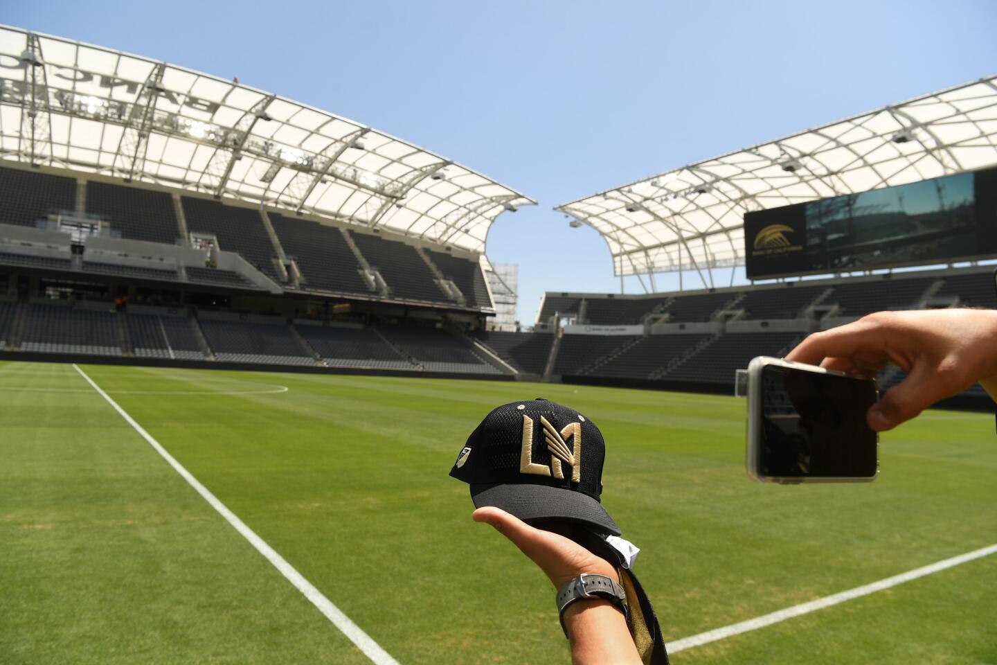 An LAFC fan takes a photo inside the LAFC's new stadium after ribbon cutting ceremonies on April 18.