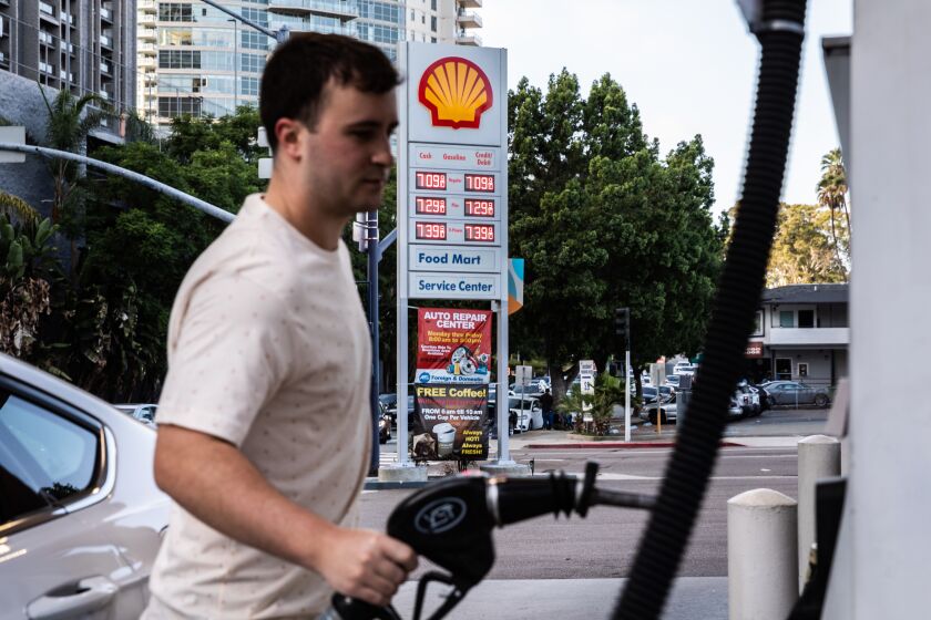San Diego, CA - October 03: Elijah Sauder pumps gas at a Shell gas station along A Street in downtown in San Diego, CA on Monday, Oct. 3, 2022. Gas prices have climb over to $7 a gallon in San Diego. (Adriana Heldiz / The San Diego Union-Tribune)