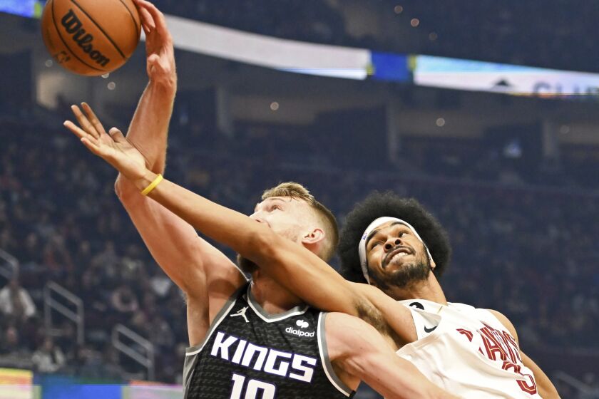 Cleveland Cavaliers center Jarrett Allen, right, fights for a rebound against Sacramento Kings forward Domantas Sabonis during the first half of an NBA basketball game, Friday, Dec. 9, 2022, in Cleveland. (AP Photo/Nick Cammett)