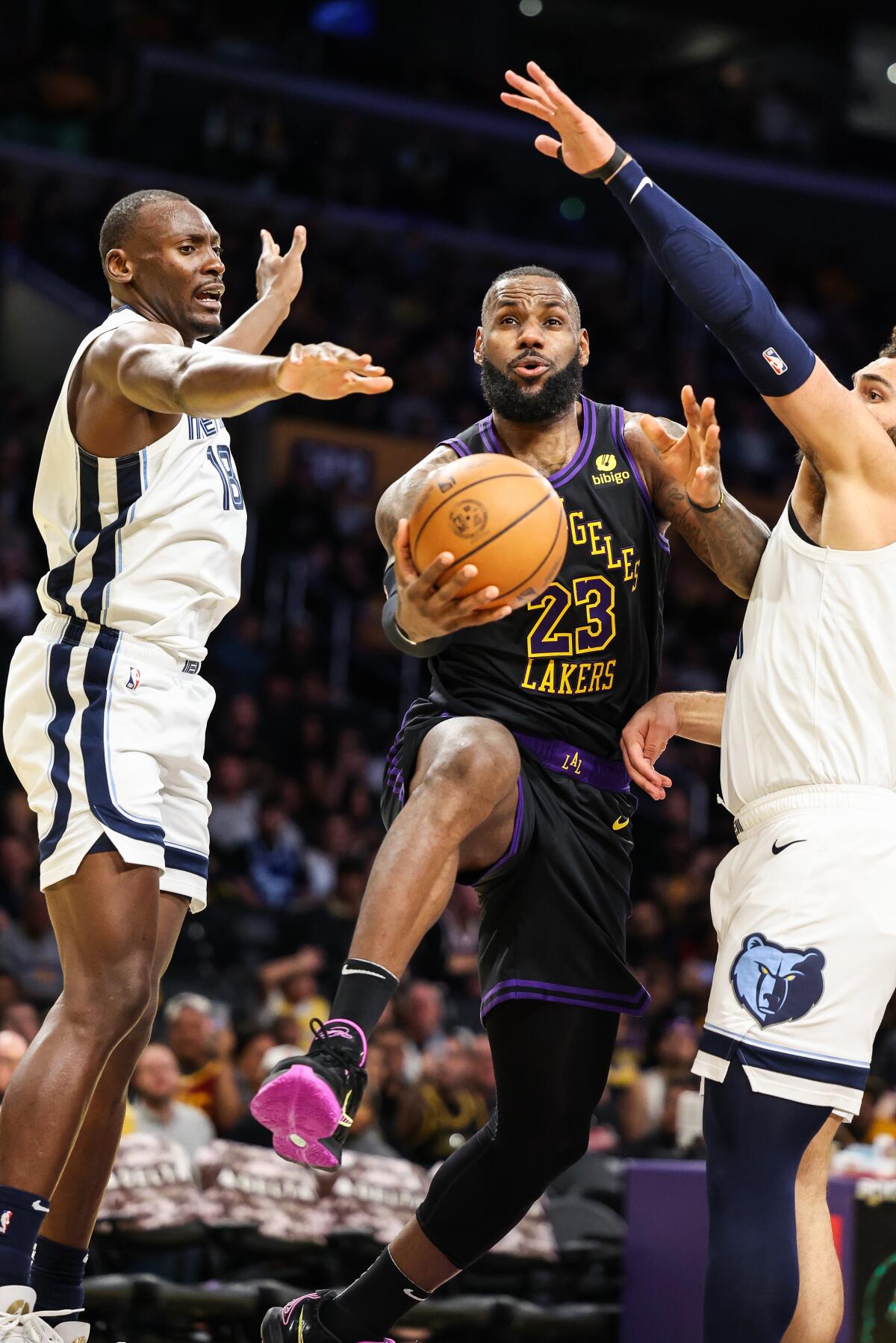 LeBron James goes up between Memphis' Bismack Biyombo(L) and David Roddy(R) during the third quarter.