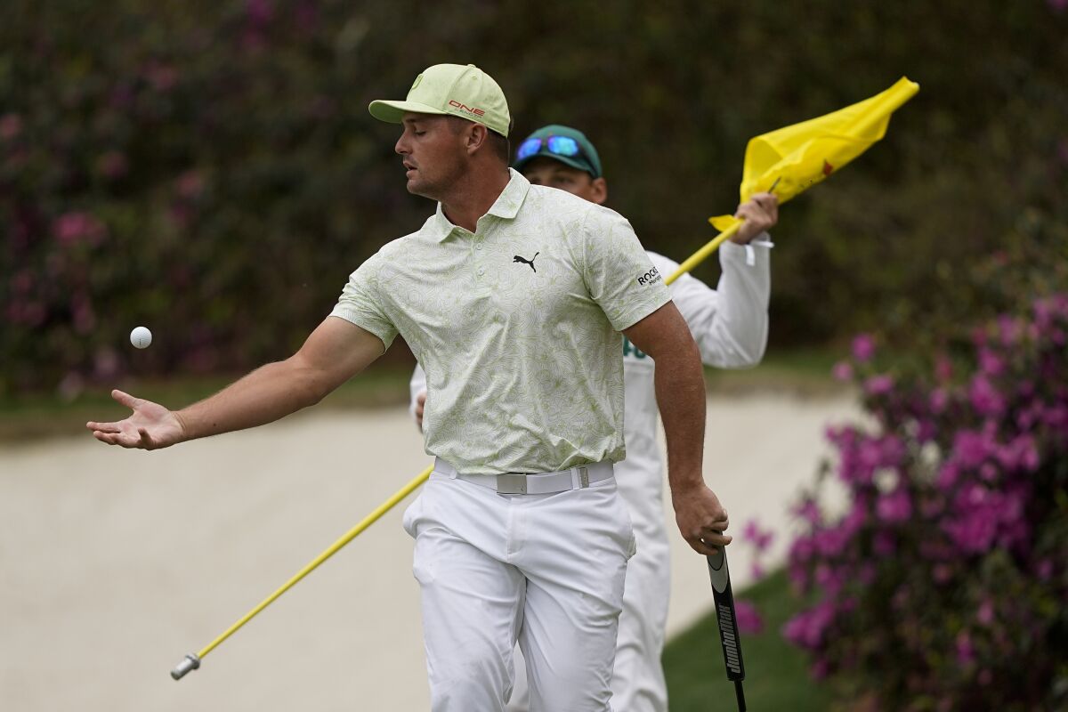 Bryson DeChambeau reaches out to catch his ball after putting on the 13th green during the second round at the Masters golf tournament on Friday, April 8, 2022, in Augusta, Ga. (AP Photo/David J. Phillip)