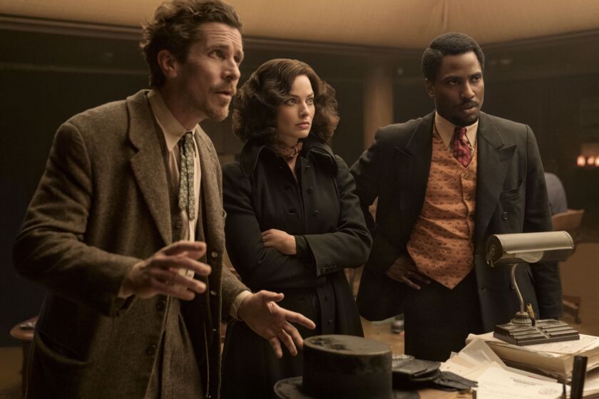 This image released by 20th Century Studios shows, from left, Christian Bale, Margot Robbie and John David Washington in a scene from "Amsterdam." (Merie Weismiller Wallace/20th Century Studios via AP)