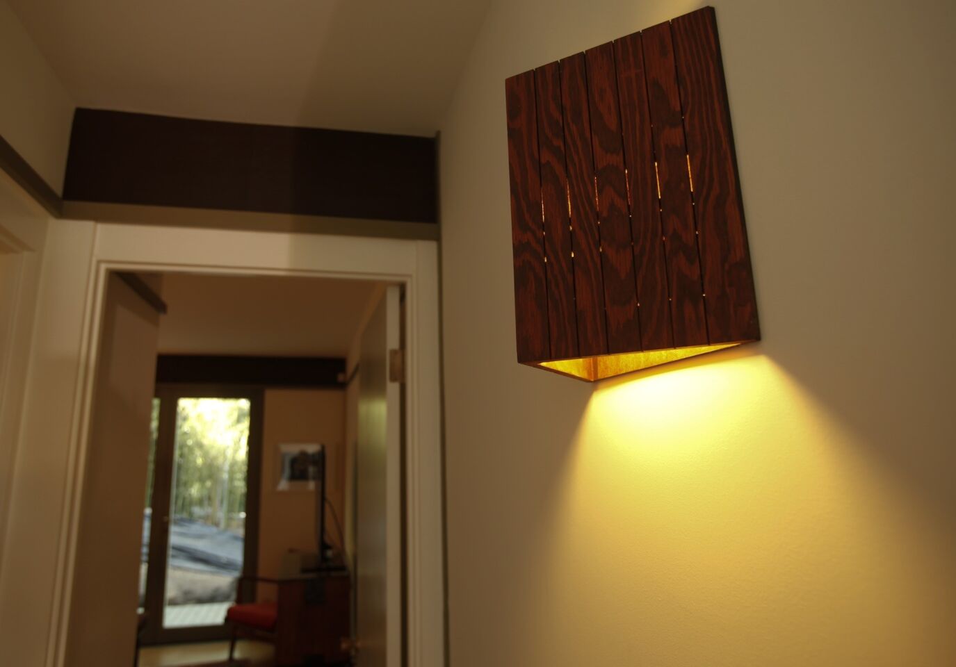 A triangular wood sconce in the hallway.
