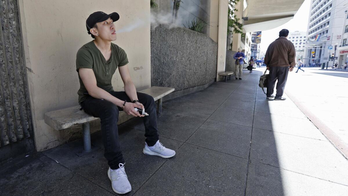A man takes a vaping break from his job at a smoke shop in San Francisco on June 17.