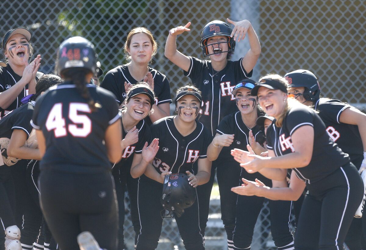 The Huntington Beach softball team congratulates teammate Tea Gutierrez (45) after she hit a home run.