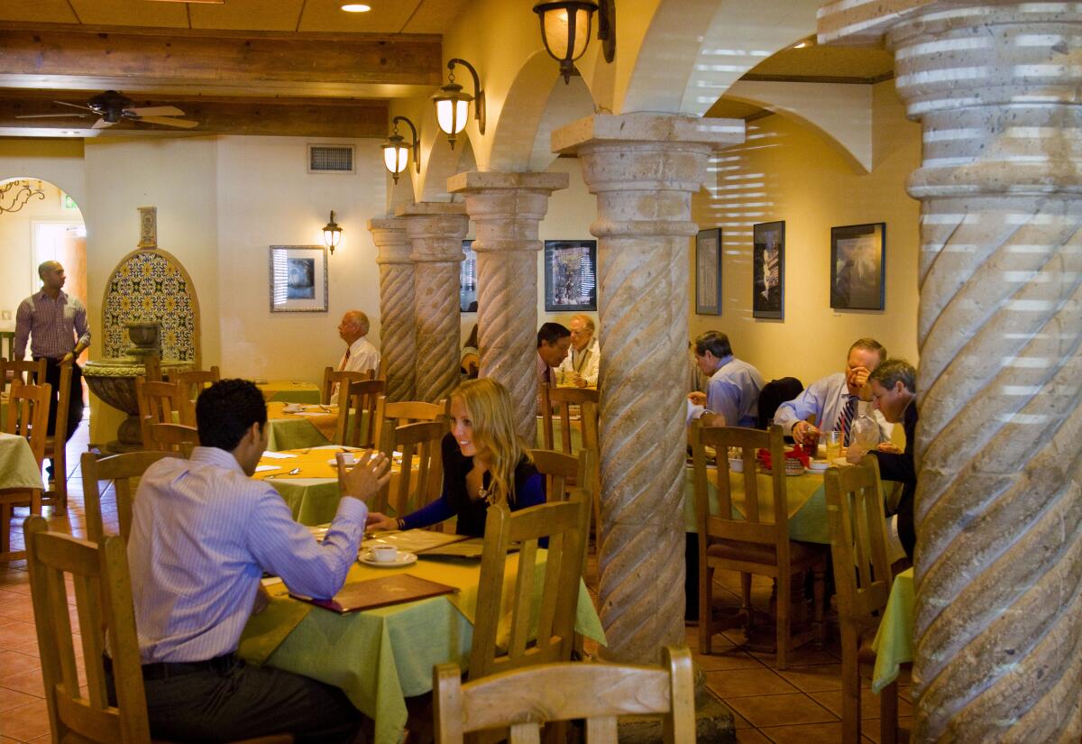 People sit at tables inside a restaurant.