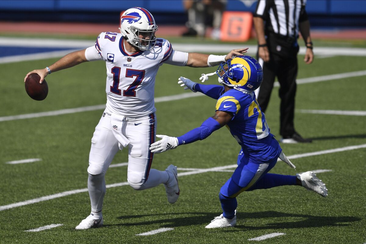 Buffalo Bills quarterback Josh Allen stiff-arms Rams cornerback Troy Hill.