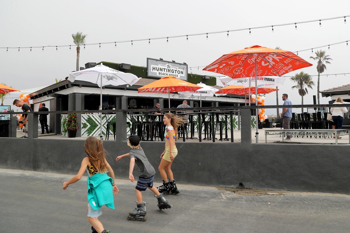 In-line skaters cruise along a pedestrian path in front of the newly opened Huntington Beach House on Thursday.