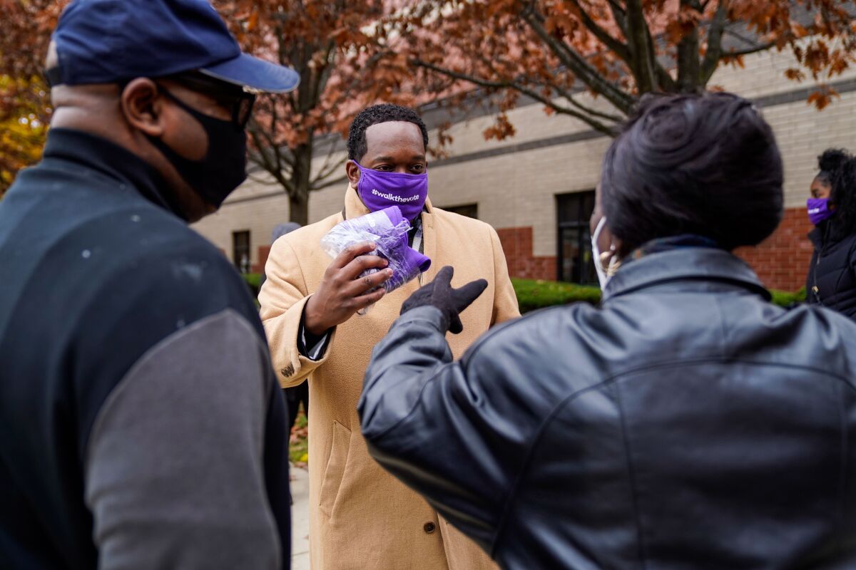 Shannon Rochon, 38, of Detroit hands out masks during a Walk the Vote event at Greater Grace Temple.