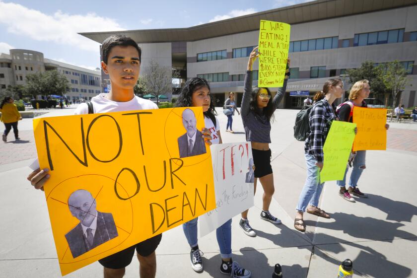 Cal State University San Marcos student Eduardo Negron, left, president of the Cal State San Marcos Democrats, along with fellow students, Faith Garcia, Patsy (wouldn't give last name), Maddie Carmichael, and Val Battle Haddock, right, held a noontime protest in front of Kellogg Library on the campus, September 10, 2019, in San Marcos, California, protesting Michael Schroder, dean of extended learning and associate vice president for international programs, who's travel expenses while on university business are under investigation by the Chancellor's Office.