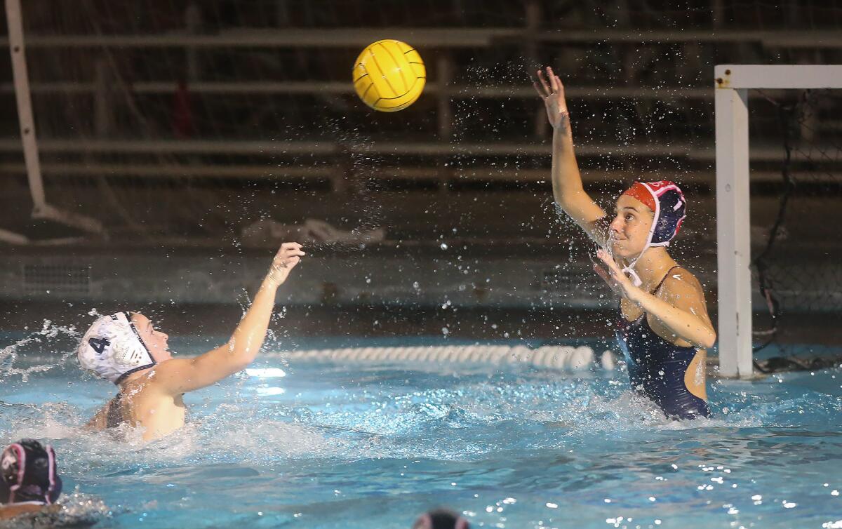 Newport Harbor's Morgan Netherton shoots high over Corona del Mar goalkeeper Maya Avital and scores a goal during the Battle of the Bay match on Thursday in Newport Beach.