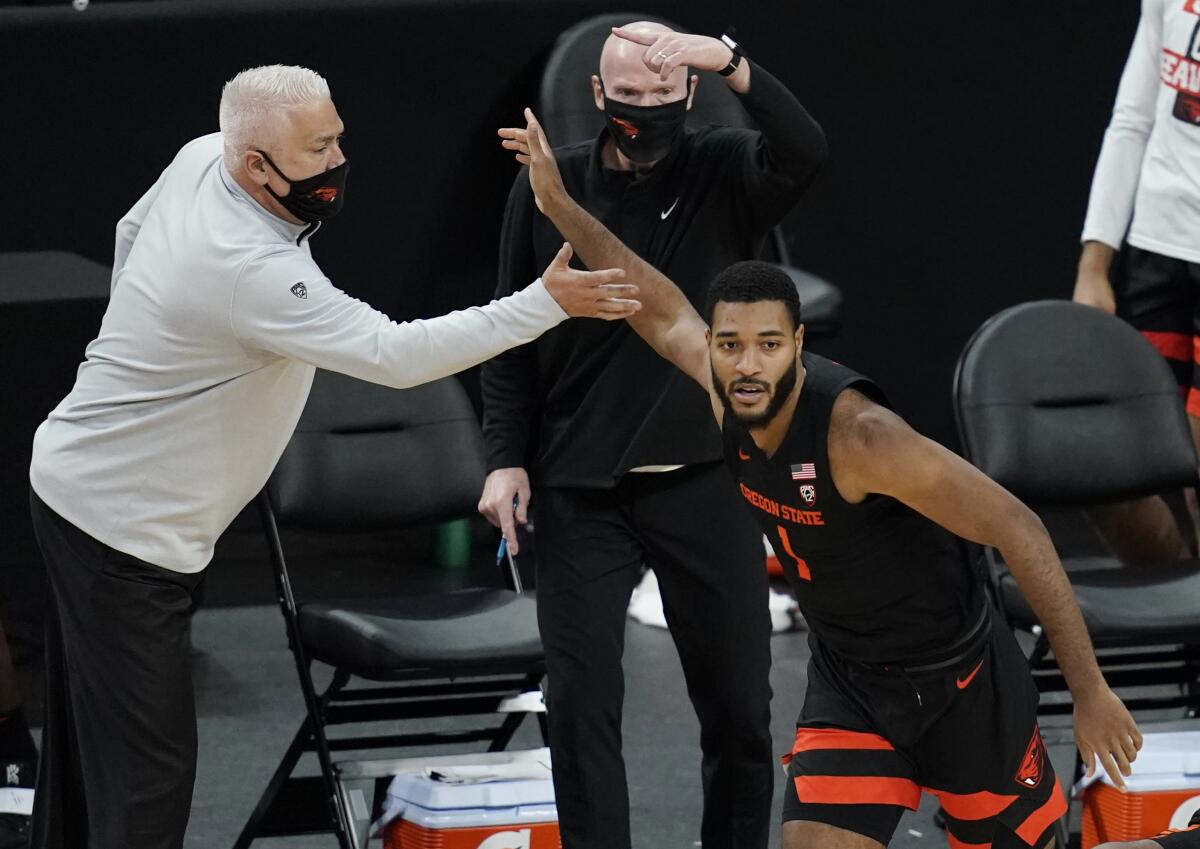 Oregon State coach Wayne Tinkle, left, celebrates with Maurice Calloo after Calloo hit a three-pointer.