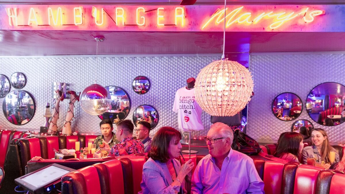 A couple, surrounded by other diners, share a drink while they enjoy their wedding-anniversary celebration brunch at Hamburger Mary's in West Hollywood.