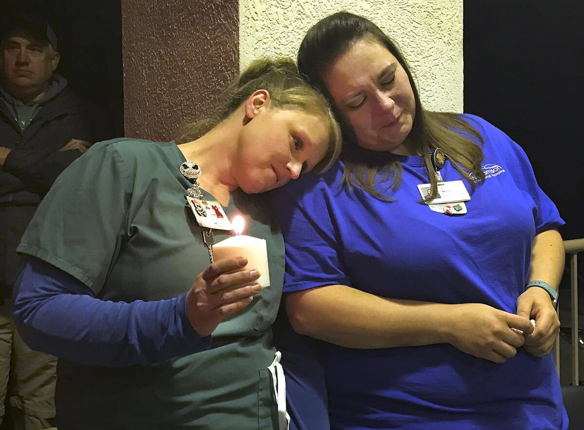 Chasity Scott and Jessica Wolford take part in a candlelight vigil outside Williamson Memorial Hospital. 