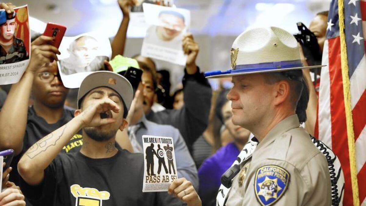 James Nelson, agente de la Policía de Caminos de California se encuentra fuera de la oficina del gobernador Jerry Brown frente a los partidarios del movimiento "Black Lives Matter", luego de que el gobernador firmara la ley AB 953.