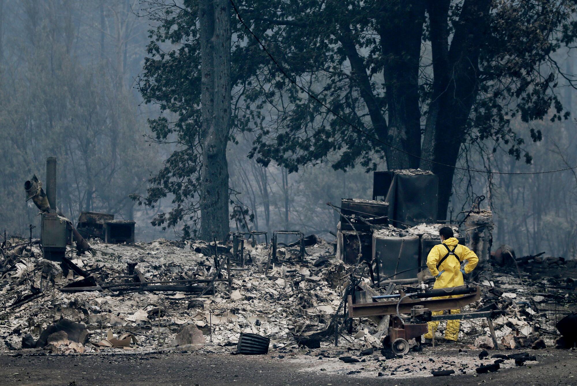 A search and rescue worker looks through the remains of a home.