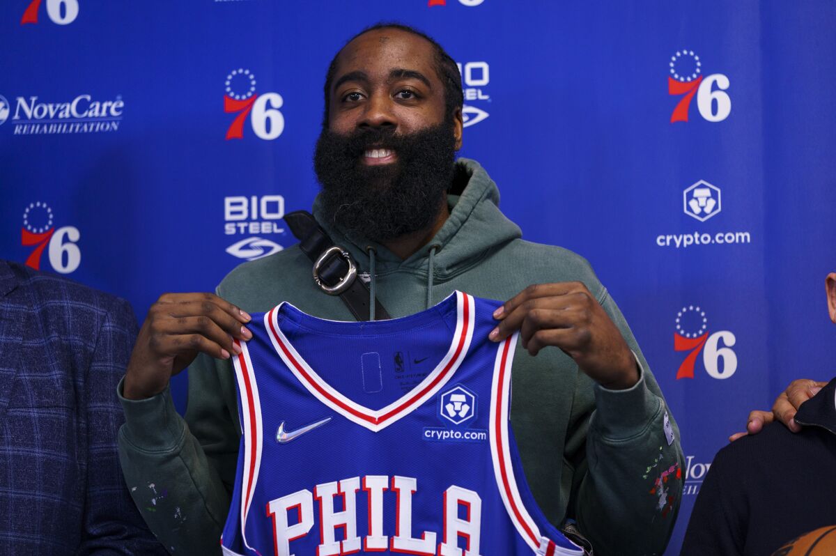 Philadelphia 76ers' James Harden holds up his new jersey after taking questions from the media at a press conference at the NBA basketball team's facility, Tuesday, Feb. 15, 2022, in Camden, N.J. (AP Photo/Chris Szagola)