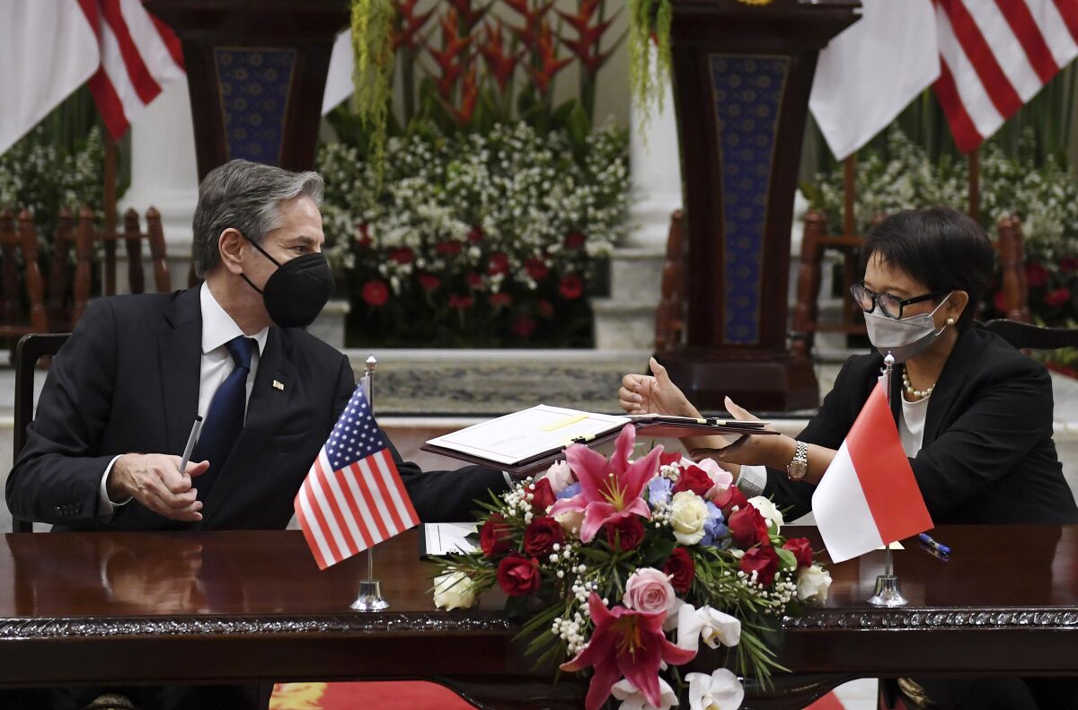 U.S. Secretary of State Antony Blinken, left, and Indonesian Foreign Minister Retno Marsudi sign a Memorandum of Understanding at the Pancasila Building in Jakarta, Tuesday, Dec. 14, 2021. (Olivier Douliery/Pool Photo via AP)