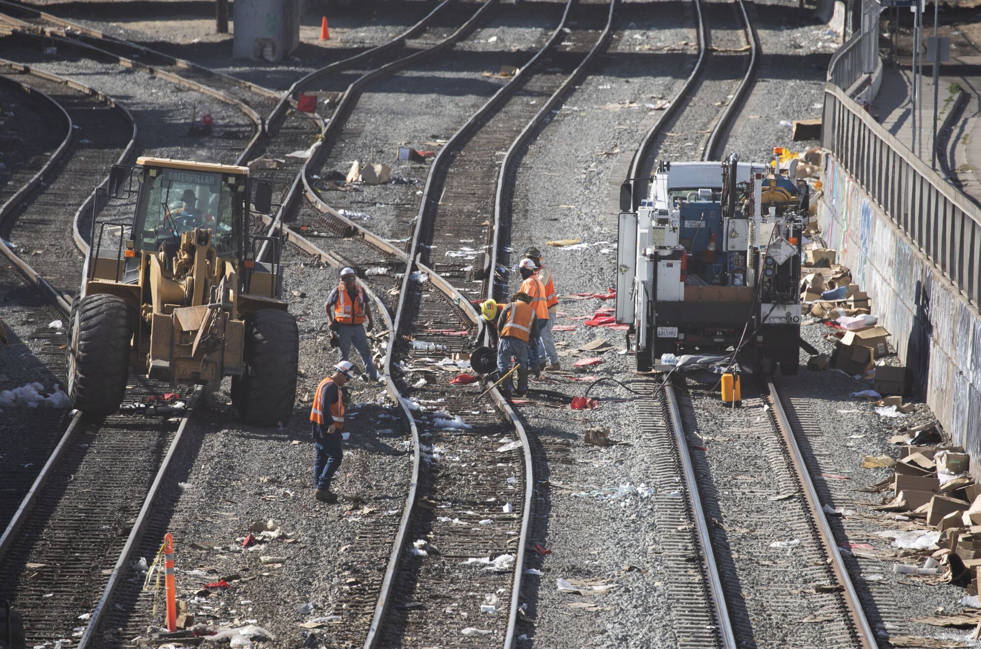 Crews repair a section of detached railroad track near downtown Los Angeles on Sunday.