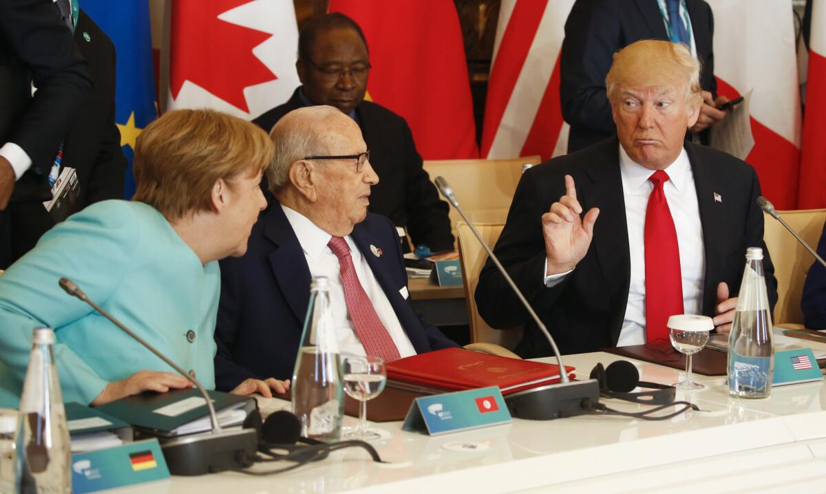 President Trump talks to German Chancellor Angela Merkel and Tunisian President Beji Caid Essebsi at a G-7 summit expanded session in Taormina, Italy, on May 27.