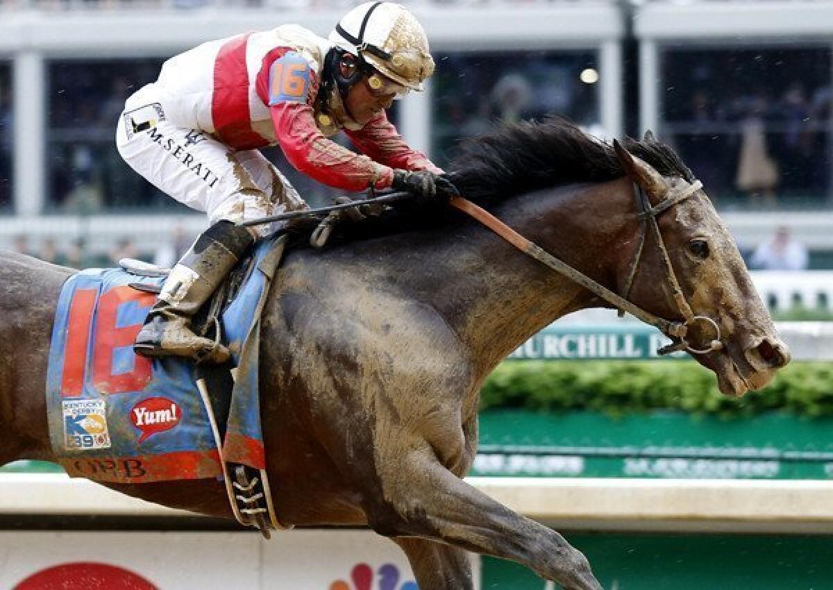 Jockey Joel Rosario guides Orb to victory in the 139th Kentucky Derby on Saturday over a sloppy Churchill Down track.
