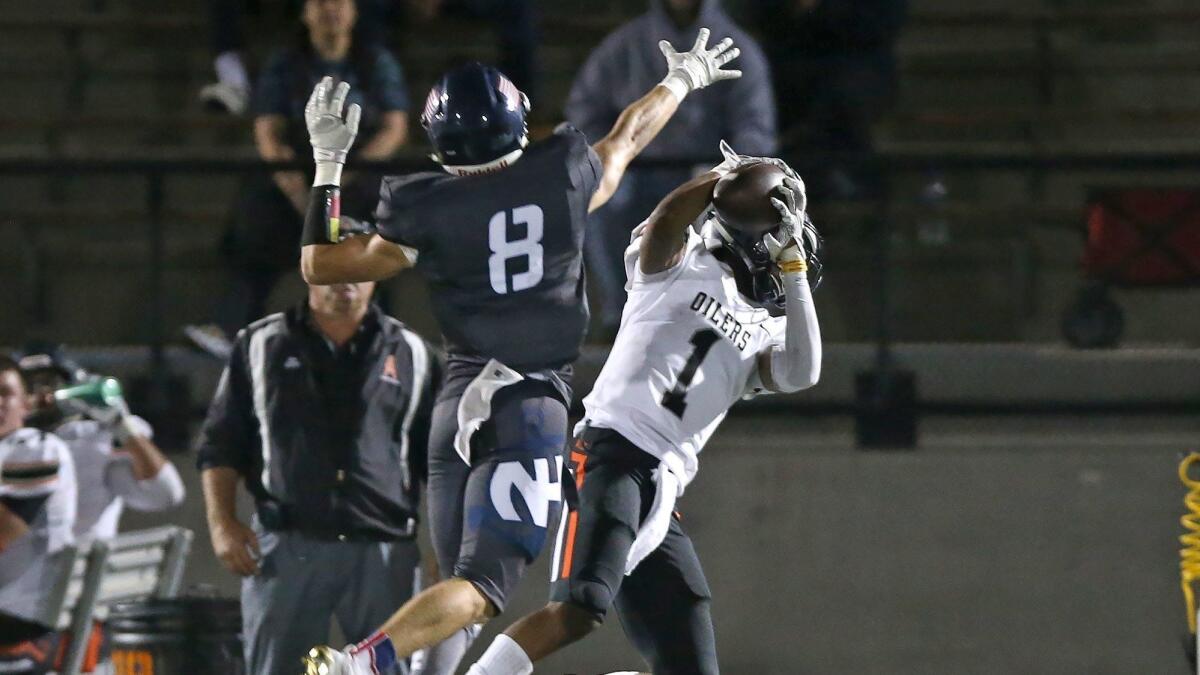 Huntington Beach High wide receiver Jeremiah Flanagan makes a big catch as Newport Harbor's Ronin Reid defends during a Sunset League game on Friday.