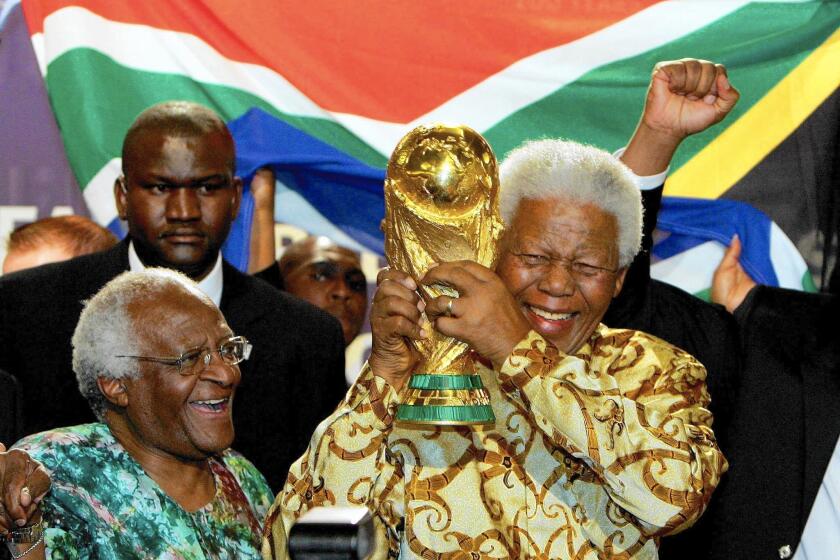 Nelson Mandela, with Capetown Archbishop Desmond Tutu, raises the Jules Rimet World Cup in Zurich in 2004, after FIFA announced that South Africa would host the 2010 World Cup.