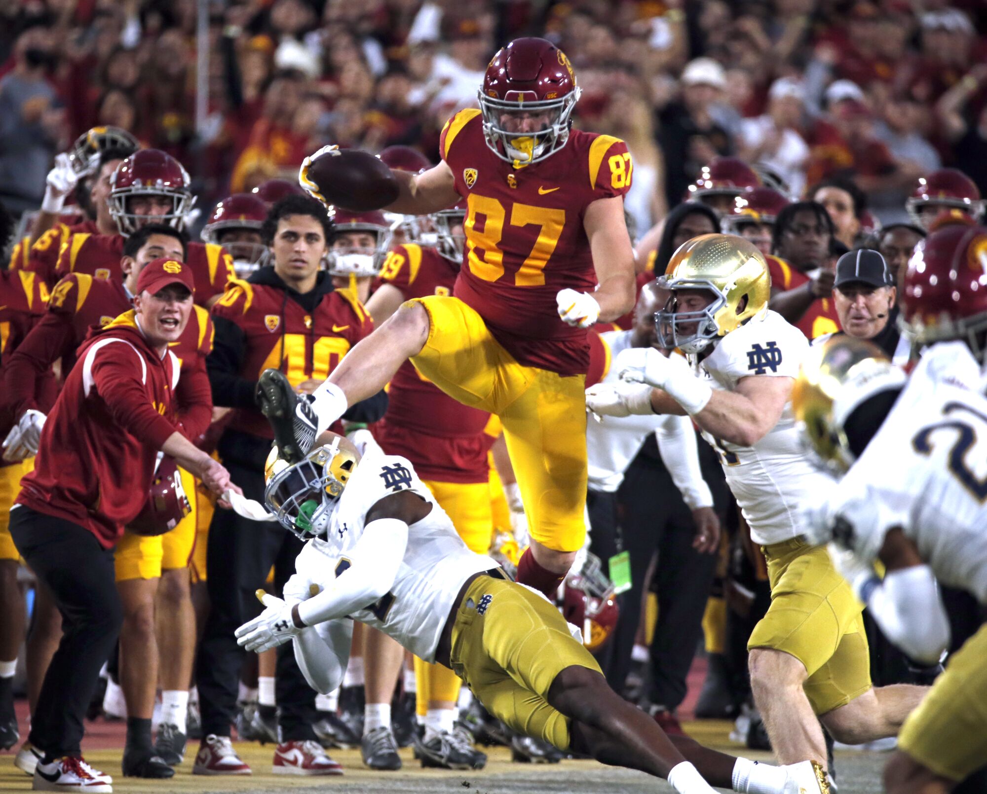 USC tight end Lake McRee hurdles over Notre Dame defensive back DJ Brown in the first quarter.