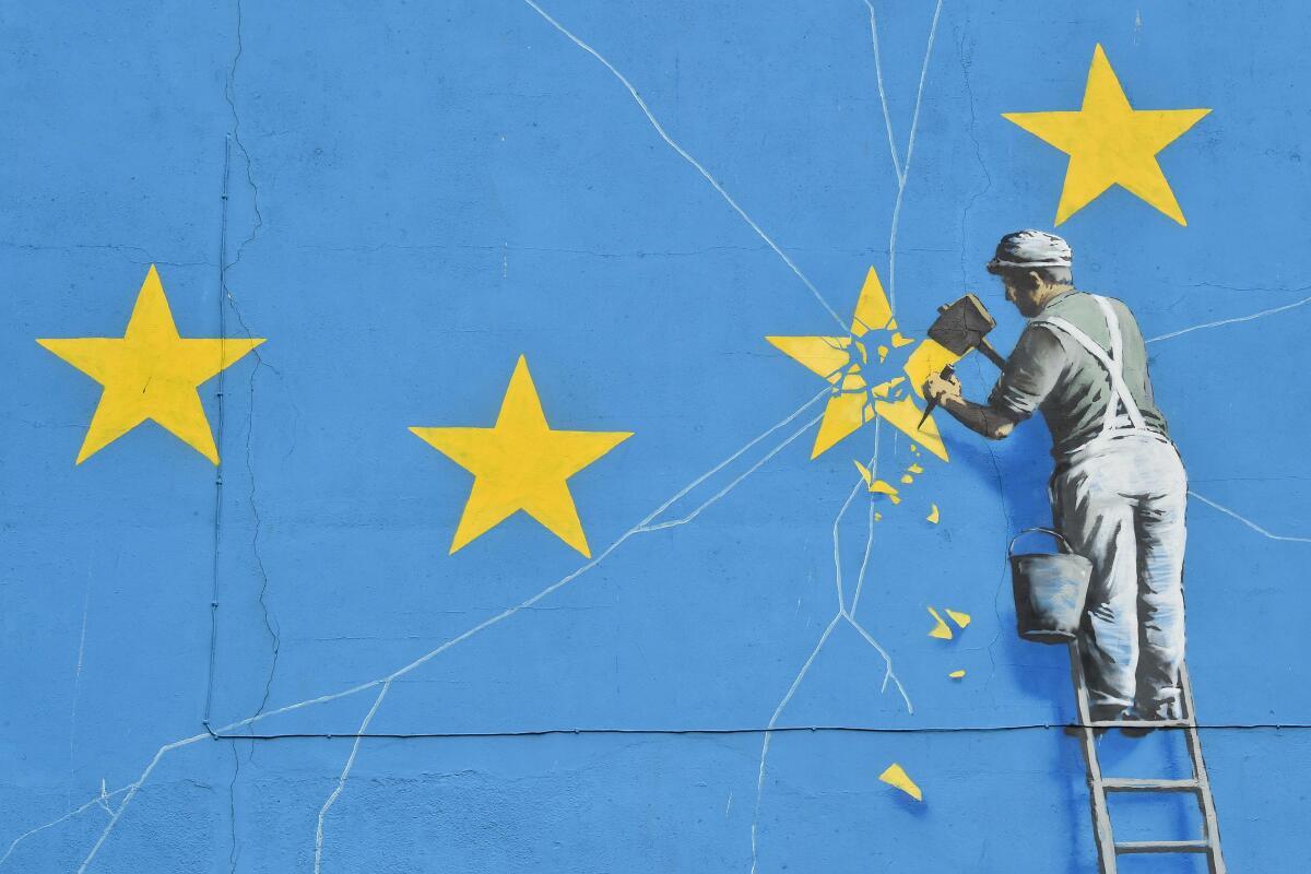 A mural by British artist Banksy depicts a workman chipping away at one of the stars on a European Union flag in Dover, England. 