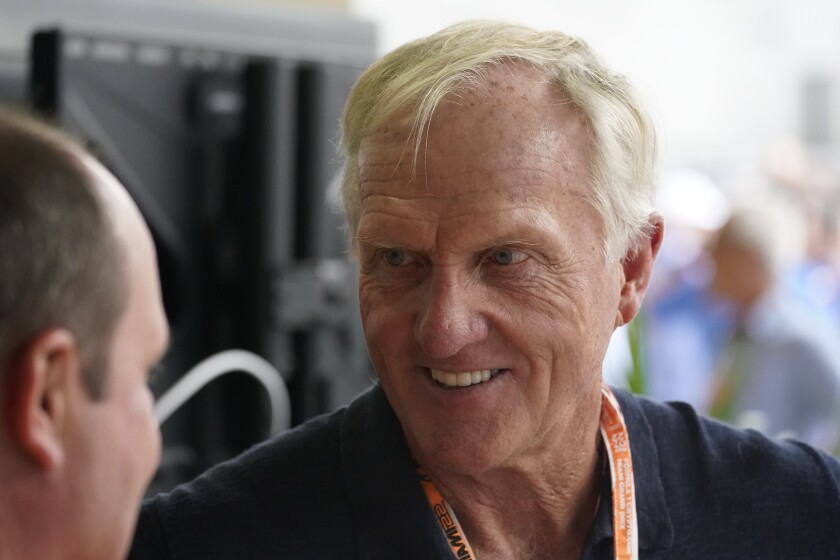 Professional golfer Greg Norman walks through the pit area during the third practice session for the Formula One Miami Grand Prix auto race at the Miami International Autodrome, Saturday, May 7, 2022, in Miami Gardens, Fla. (AP Photo/Darron Cummings)
