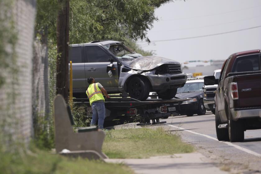 Emergency personnel take away a damaged vehicle after a fatal collision in Brownsville, Texas, on Sunday, May 7, 2023. Several migrants were killed after they were struck by a vehicle while waiting at a bus stop near Ozanam Center, a migrant and homeless shelter. (AP Photo/Michael Gonzalez)