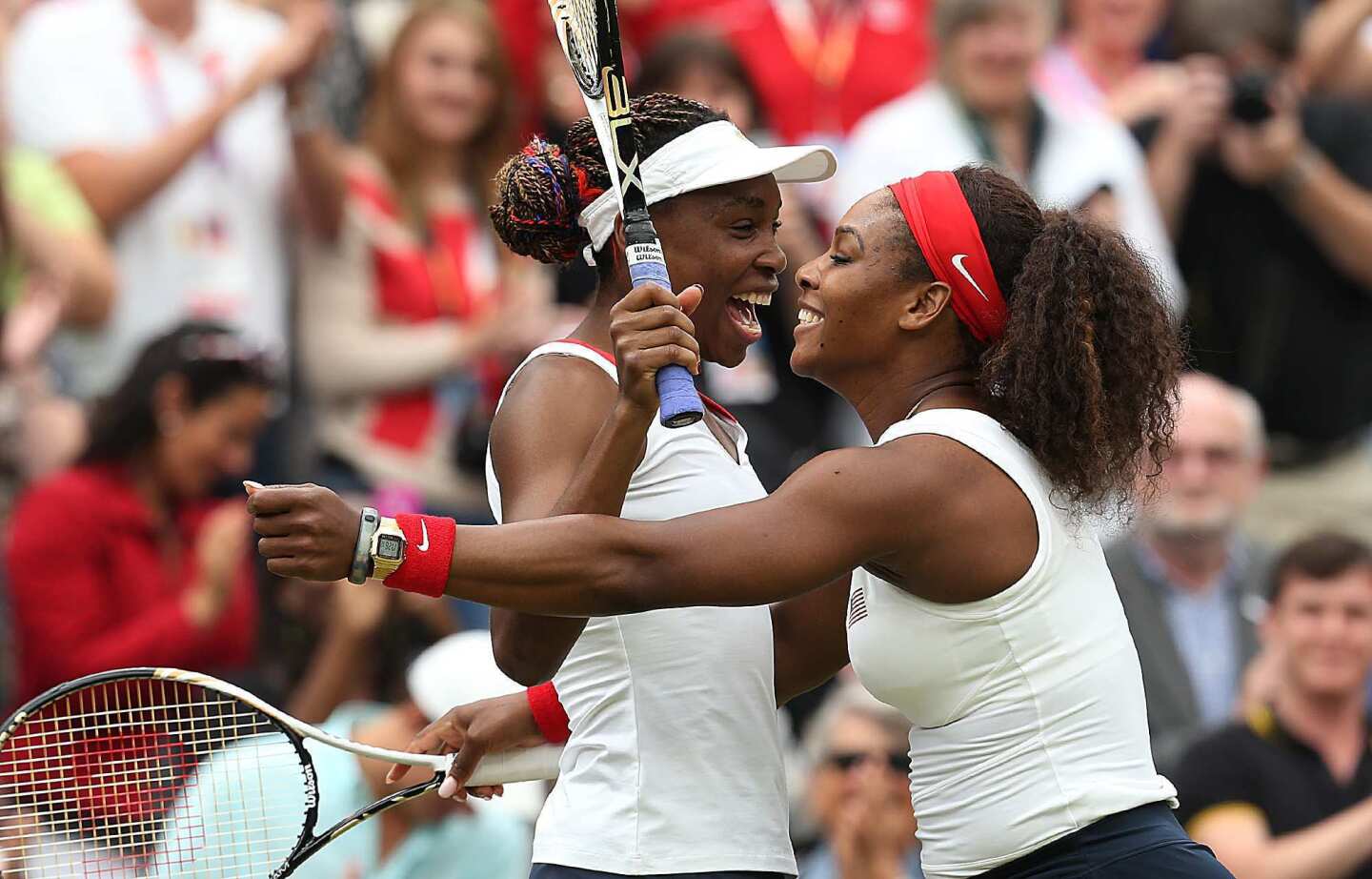 Venus and Serena Williams of Team USA celebrate on Wimbledon's Center Court after winning the women's doubles final. Each sister now has four Olympic gold medals.