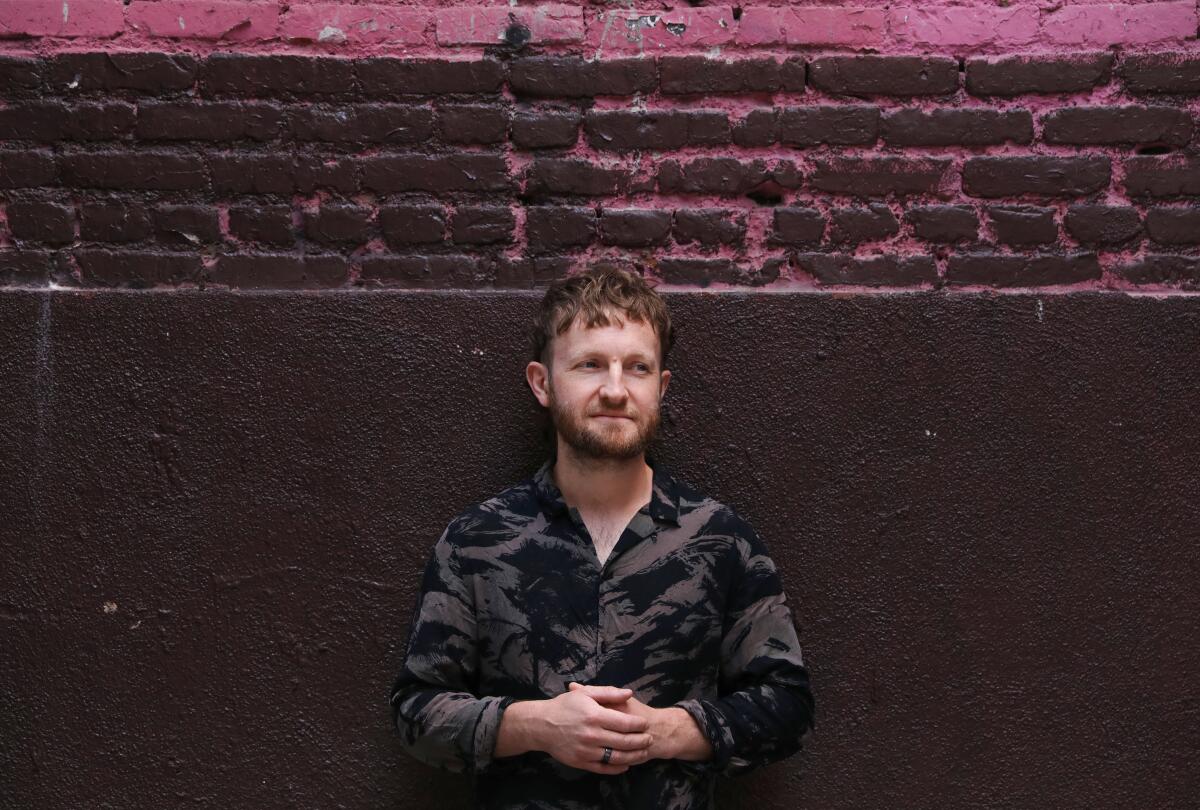 A man in front of a brick wall